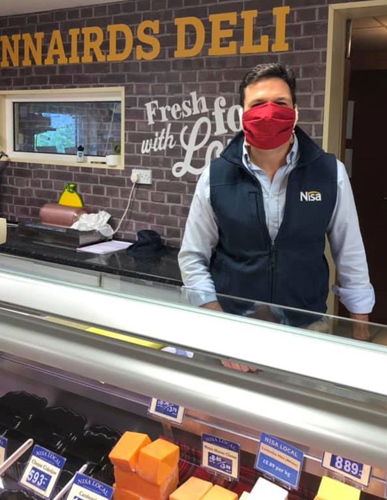 Celebrating a century satisfying shoppers employee stood at dairy counter